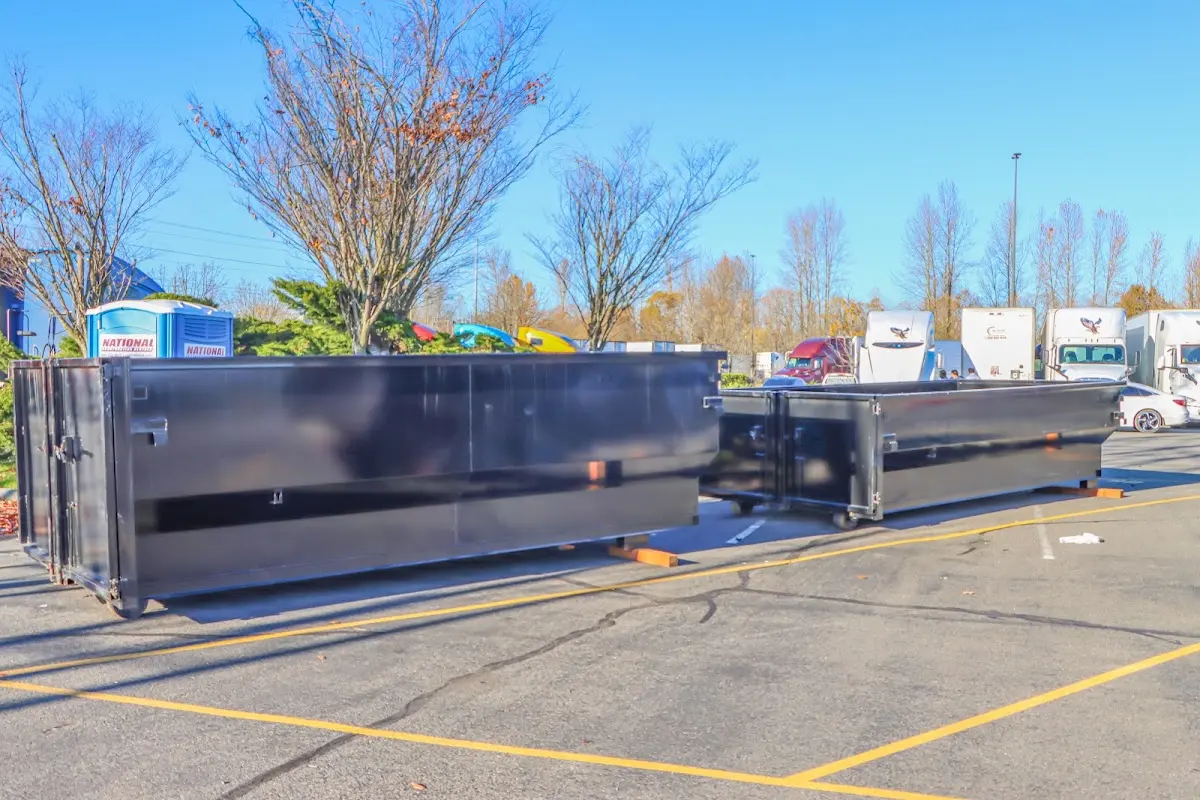 Professional dumpster rental service with roll-off container on residential driveway in Rendon